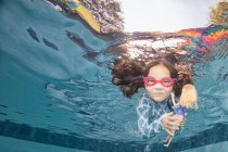 Underwater portrait of girl swimming holding doll — Stock Photo