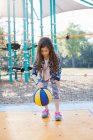 Junges Mädchen hüpft Basketball auf Spielplatz — Stockfoto