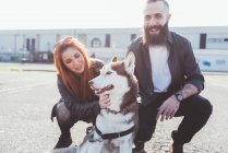 Junges Paar spielt mit Hund im Freien — Stockfoto