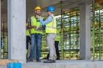 Construction workers in discussion on building site — Stock Photo