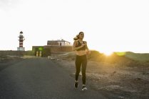 Giovane donna corridore su strada rurale al tramonto, Las Palmas, Isole Canarie, Spagna — Foto stock