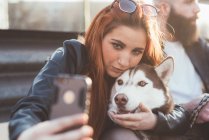 Jeune femme prenant selfie avec chien — Photo de stock
