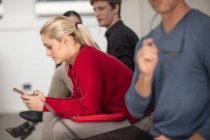 Чоловіки і жінки офісні працівники дивляться за допомогою ноутбука і смартфона на зустрічі — стокове фото