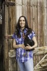 Portrait of young woman holding chicken on ranch, Bridger, Montana, USA — Stock Photo