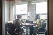 Две женщины, работающие с цифровыми планшетами в конференц-зале — стоковое фото