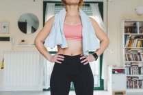 Молодая женщина в спортивной одежде стоит с руками на бедрах — стоковое фото