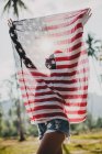 Junge Frau hält amerikanische Flagge hoch, Krabi, Thailand — Stockfoto