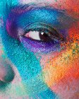 Young woman face with multi colored powder eye shadow — Stock Photo