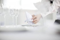 Camarera poniendo mesa en restaurante, sección media - foto de stock