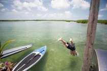 Homem maduro mergulhando na água da costa — Fotografia de Stock
