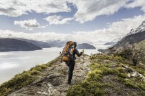 Malerischer Blick auf männliche Wanderer mit Blick auf grauen See und Gletscher, Torres del Paine Nationalpark, Chili — Stockfoto