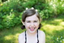Retrato de menina ao ar livre, vestindo margaridas no cabelo, sorrindo — Fotografia de Stock