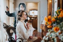 Bride preparing for wedding with hairstylist — Stock Photo