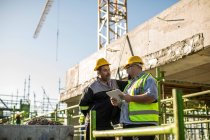 Construction workers in discussion on building site — Stock Photo