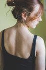 Visão traseira retrato de mulher jovem olhando sobre o ombro — Fotografia de Stock