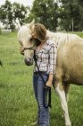 Giovane donna che bacia cavallo nel campo ranch, Bridger, Montana, Stati Uniti d'America — Foto stock