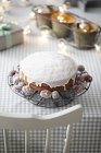 Iced cake on table with decorative lights — Stock Photo