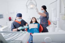 Dentista e infermiere dentale con paziente — Foto stock