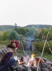 Mulher sentada ao lado de fogueira e comida culinária, Colgate Lake Wild Forest, Catskill Park, New York State, EUA — Fotografia de Stock