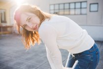 Retrato de jovem mulher no terraço do telhado iluminado pelo sol — Fotografia de Stock