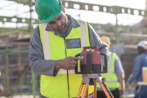 Trabalhador da construção civil que utiliza equipamento de vistoria — Fotografia de Stock