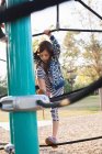 Menina de pé em cordas no quadro de escalada no parque infantil — Fotografia de Stock