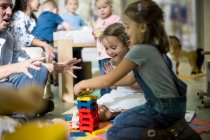 Teacher and children playing with building blocks — Stock Photo
