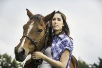 Портрет молодої жінки, що стоїть з конем — стокове фото