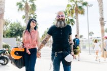 Retrato de pareja hipster madura paseando por la acera, Valencia, España - foto de stock