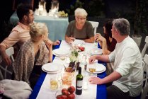 Group of people sitting at table, enjoying meal — Stock Photo