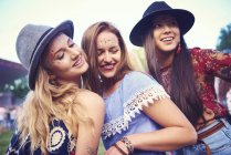 Drei junge Freundinnen in Fedoras tanzen auf einem Festival — Stockfoto