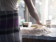 Visão traseira do homem que prepara a massa de farinha na cozinha — Fotografia de Stock