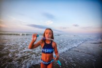 Girl blowing soap bubbles on beach — Stock Photo