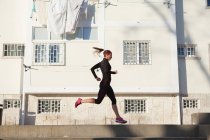 Vista lateral de jogging jovem mulher — Fotografia de Stock
