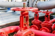 Закрытие красных промышленных труб и клапанов на заводе биотоплива — стоковое фото