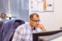 Männlich Büroangestellte Blick auf Desktop-Computer am Schreibtisch — Stockfoto