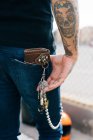 Rear view of man with keys in back pocket and skull tattoo, cropped — Stock Photo