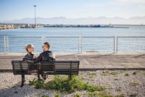 Vista traseira do casal sentado no banco, Cagliari, Sardenha, Itália, Europa — Fotografia de Stock