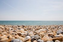 Pebble beach and seascape on horizon, England — Stock Photo