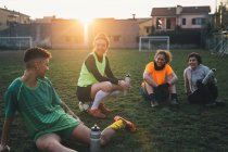 Football players taking break on pitch — Stock Photo