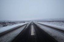 Vue sur la route asphaltée et les montagnes dans la neige — Photo de stock