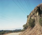Самотня лавка біля дороги та скелі — стокове фото