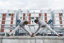 Молоді чоловіки тренування близнюків зігнуті вперед розтягування — стокове фото