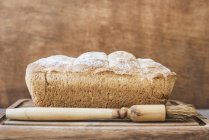 Close-up view of Fresh baked loaf of bread on a wooden surface — Stock Photo
