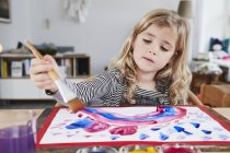 Menina jovem pintura quadro à mesa — Fotografia de Stock
