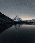 Matterhorn reflecting over Lake Riffelsee at night, Zermatt, Valais, Switzerland — Stock Photo