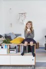 Junges Mädchen sitzt im Wohnzimmer mit Glas Milch — Stockfoto