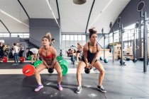Жінки тренуються в спортзалі за допомогою чайників — стокове фото