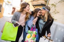 Amici fuori shopping e ridere in strada — Foto stock