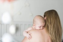 Mother and baby girl in nursery room — Stock Photo